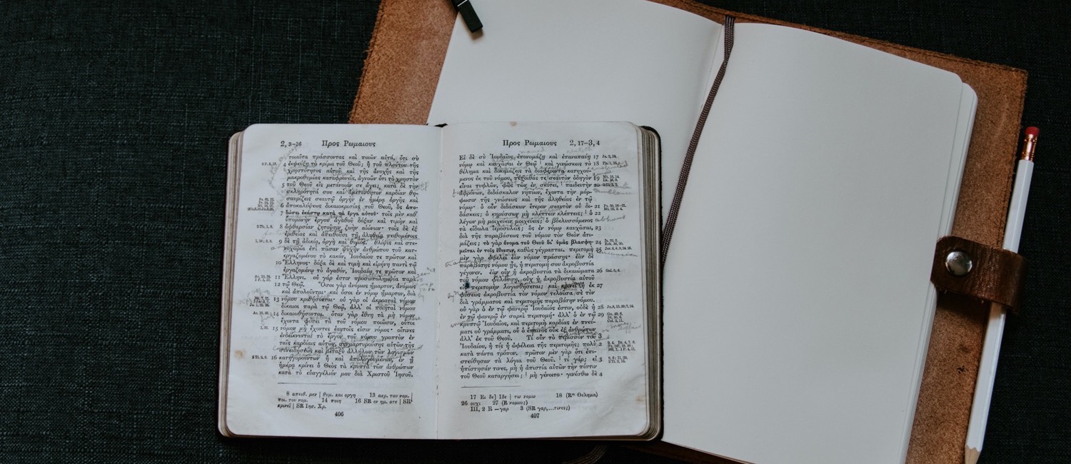 Greek Bible laying open on top of notebook
